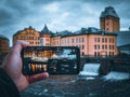 View of a cropped hand holding a phone against cityscape Royalty Free Stock Photo