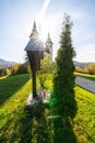 View on the cross in front of the Church of St. Volbenka in autumn colors against a blue sky, Slovenia, Europe.