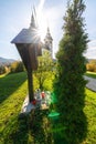 View on the cross in front of the Church of St. Volbenka in autumn colors against a blue sky, Slovenia, Europe.