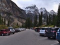 View of crowded parking lot of Moraine Lake, Banff National Park in the Canadian Rocky Mountains on cloudy day with Mount Bowlen. Royalty Free Stock Photo
