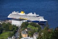 View of a cruise ship with dark blue hull and yellow funnel, docked in the port from the top of the Mount Floyen.