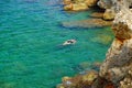 View on the crystal sea water and unknown person swiming on Menorca Royalty Free Stock Photo