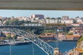 View of D. Luis bridge, with two subways to cross at the top, Douro river with boats and Vila Nova de Gaia city as background