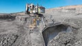 View of a D11 type tractor and giant excavators in the process of extracting minerals in an open pit mine Royalty Free Stock Photo