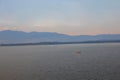 View of the dam in the evening The sun is about to set. with a small red rowing boat with a mountain backdrop Royalty Free Stock Photo