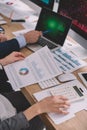 View of data analysts using computers, papers with graphs and calculator at table