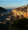 View at the dawn of Portovenere and harbor with moored boats, sea, colorful buildings, trees Royalty Free Stock Photo