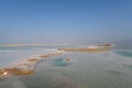 View of Dead Sea coastline with it`s beautiful sand and salt in the middle of the water. Aerial shot captured from the Royalty Free Stock Photo