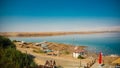 Tourists relaxing and swimming in the water of the Dead Sea in I