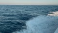 View from the deck of the yacht at the bow, close up. Blue sea water with boat trace. View from the back of a ship over Royalty Free Stock Photo