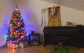 A view of a decorative Christmas tree and a piano Royalty Free Stock Photo