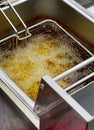 View of deep frying of spring or tornado potato chips,in oil