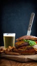 View of delicious burger and fries with glass of beer on wooden table Royalty Free Stock Photo