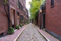 View of a deserted narrow stone alley lined with historic brick residential buildings Royalty Free Stock Photo