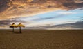 View on deserted tropical sand beach with two umbrellas, storm clouds - early booking preseason rate concept Royalty Free Stock Photo