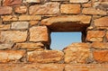 OPENING FOR A WINDOW IN AN OLD HISTORIC STONE FORT WALL WITH BLUE SKY VISIBLE Royalty Free Stock Photo