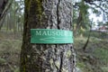 Angled view of a directional arrow sign, pointing the direction to a mausoleum deep in a forested area in the San Juan Islands Royalty Free Stock Photo