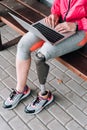 View of disabled sportswoman typing on laptop on street