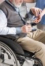 View of doctor giving pills to disabled senior man in wheelchair Royalty Free Stock Photo