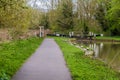 A view down the canal path towards the Aylestone Mill lock on the Grand Union Canal in Aylestone Meadows, Leicester, UK