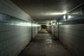 A view down a damp and dirty glazed tiled block and concrete tunnel urban or city pedestrian underpass corridor below Lake Shore Royalty Free Stock Photo