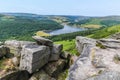 A view down a gully between gritstone boulders on Bamford Edge towards Ladybower reservoir, UK Royalty Free Stock Photo