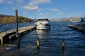 Moored boat at jetty, Lakeland fells backdrop. From Bowness-on Windermere, Cumbria