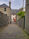 A view down the pedestrian, stone flagged Queens Lane to Commercial Street in the town centre of Lerwick, capital of Shetland