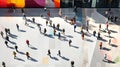 View down on white marble floor and lots of people walking in different directions