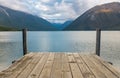 A view down a wooden jetty of the incredibly beautiful Rotoiti Lake surrounded by mountains which is part of the Nelson Lakes Royalty Free Stock Photo