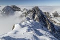 View of dramatic, rocky, snowy mountain range peaks with mist and clouds, Lomnicky Stit, High Tatras, Slovakia, European alps. Royalty Free Stock Photo