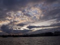 View of the dramatic sky above the sity at sunset with dark blue clouds