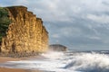 A view of the dramatic sunlit cliffs at West Bay, Dorset, UK.