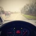 View from the driver - car interior with steering wheel and dashboard. Winter bad rainy weather and dangerous driving on the road Royalty Free Stock Photo