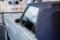 View of the driver`s side of grey retro cabriolet car with wheel arch above a whitewall tire and chrome disc, mirror on Royalty Free Stock Photo