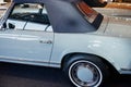 View of the driver`s side of grey retro cabriolet car with wheel arch above a whitewall tire and chrome disc, window Royalty Free Stock Photo