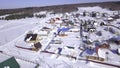 The view from the drone. Clip.Winter forests where small houses of the village are visible and large snowdrifts and blue Royalty Free Stock Photo