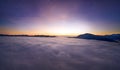 View from the drone at dawn over the clouds with mountains on the grassland. Royalty Free Stock Photo