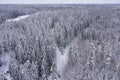 View from the drone to the snowy forest and the road. Finland. Scandinavian nature. Royalty Free Stock Photo