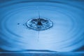 View of drops making circles on blue water surface isolated on background. Royalty Free Stock Photo