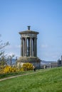 View of Dugald Stewart Monument with vegetation around and a path , in Edinburgh