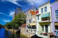 View on dutch water canal, waterfront residential houses with balconies and gothic church background, blue summer sky - Dordrecht