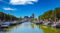 View on dutch water canal with yacht harbour, gothic church background against blue summer sky Royalty Free Stock Photo