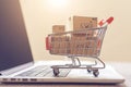 view E commerce setup laptop and miniature cart for convenient shopping Royalty Free Stock Photo