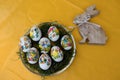 View on easter eggs and a wooden easter bunny on a yellow tablecloth