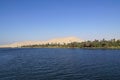 View of the Egyptian Nile with palm trees and desert behind