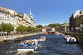 View of the embankments of the Moika river, tourist boats, the Red bridge and the Trading house `S. Esders and K. Skheifals` in