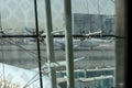 View of Emirates Airlines airplane parking on apron viewed from waiting lounge inside the terminal at Dubai Intenational Airport Royalty Free Stock Photo