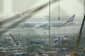 View of Emirates Airlines airplane parking on apron viewed from waiting lounge inside the terminal at Dubai Intenational Airport Royalty Free Stock Photo