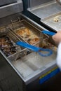 employee uses deep fryer machine Royalty Free Stock Photo